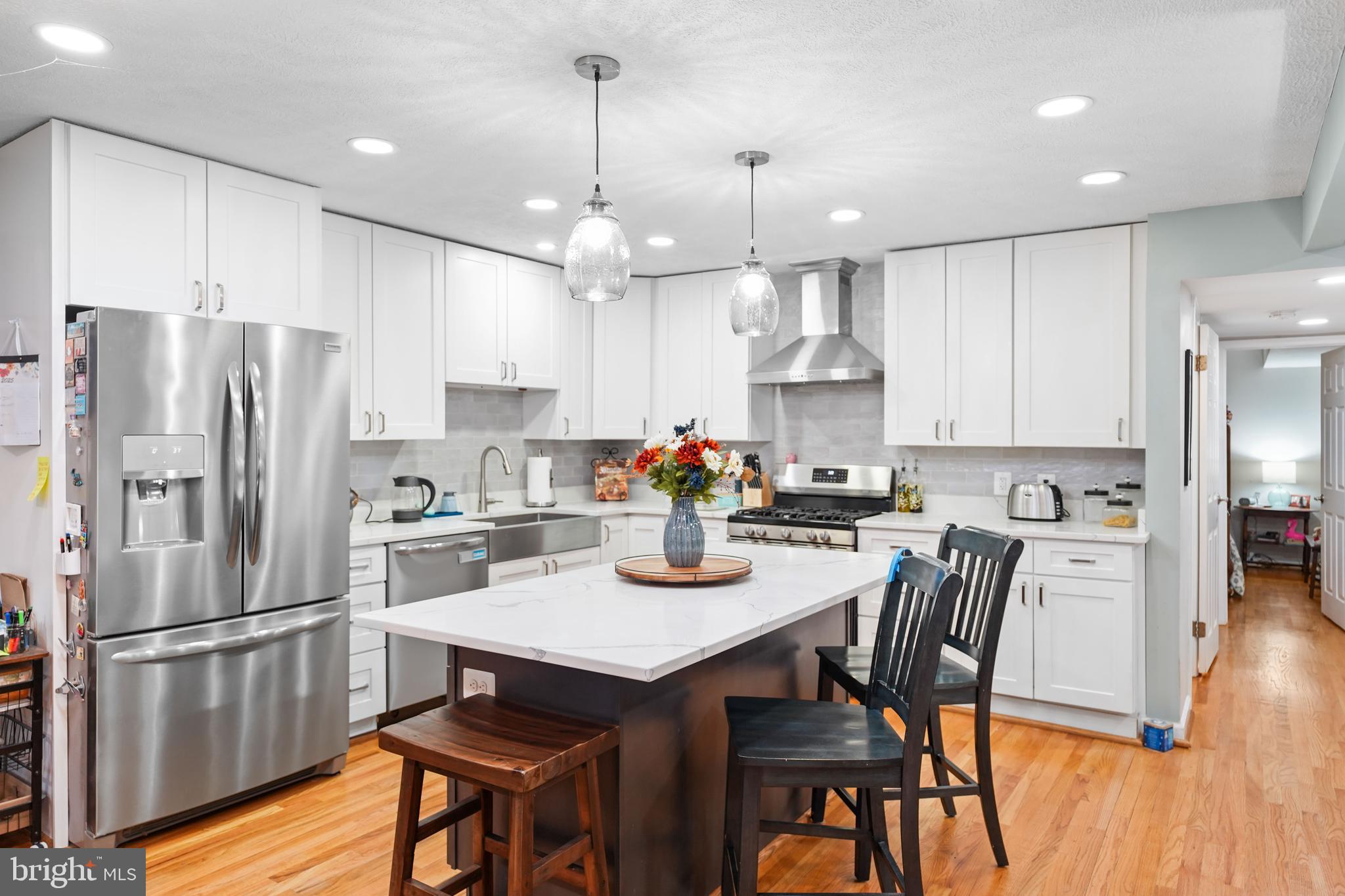10012 Ellis Road Manassas, VA 20111 - Photo 25 of 54 a kitchen with stainless steel appliances granite countertop a dining table chairs refrigerator and wooden floor