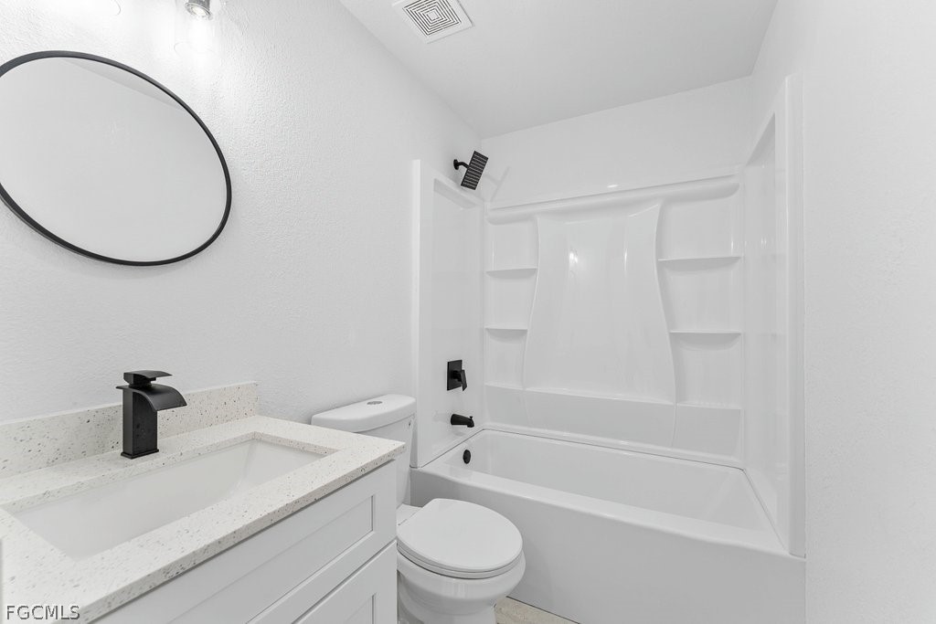 2512 42nd Street Southwest Lehigh Acres, FL 33976 - Photo 15 of 25 a bathroom with a sink a toilet and a mirror