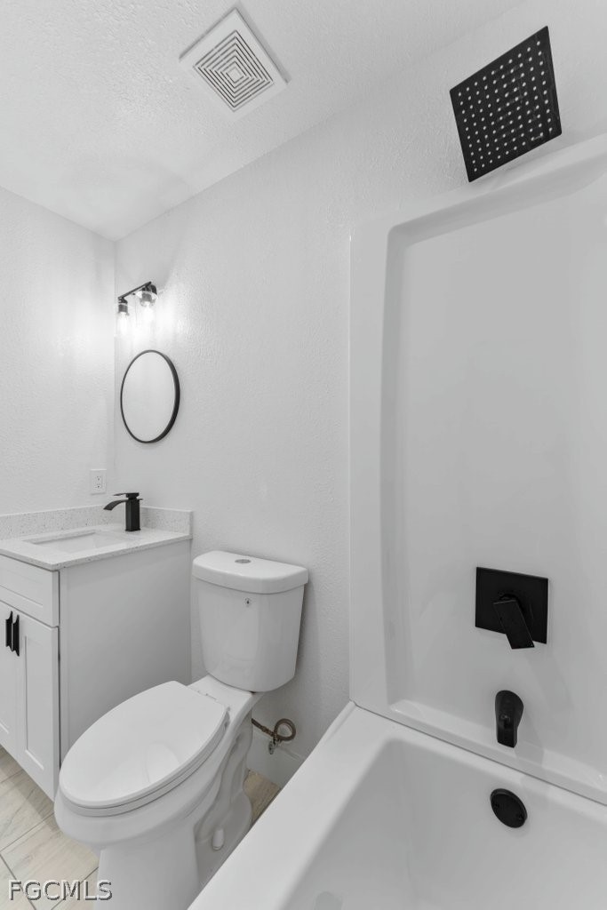 2512 42nd Street Southwest Lehigh Acres, FL 33976 - Photo 16 of 25 a bathroom with a toilet sink a mirror and shower