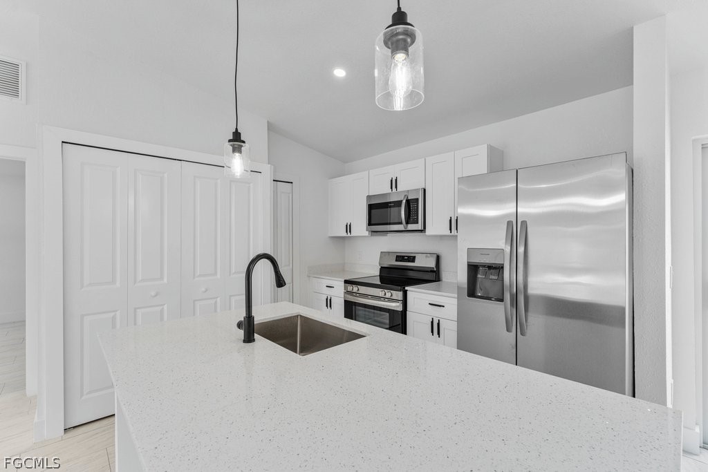 2512 42nd Street Southwest Lehigh Acres, FL 33976 - Photo 3 of 25 a kitchen with stainless steel appliances granite countertop a refrigerator a sink a stove and white cabinets