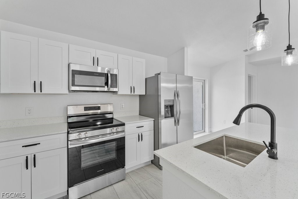 2512 42nd Street Southwest Lehigh Acres, FL 33976 - Photo 4 of 25 a kitchen with a sink cabinets and stainless steel appliances