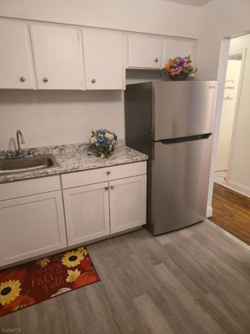 22 Sunset Avenue, Unit 2 Bayonne, NJ 07002 - Photo 9 of 11 a kitchen with granite countertop a sink cabinets and stainless steel appliances