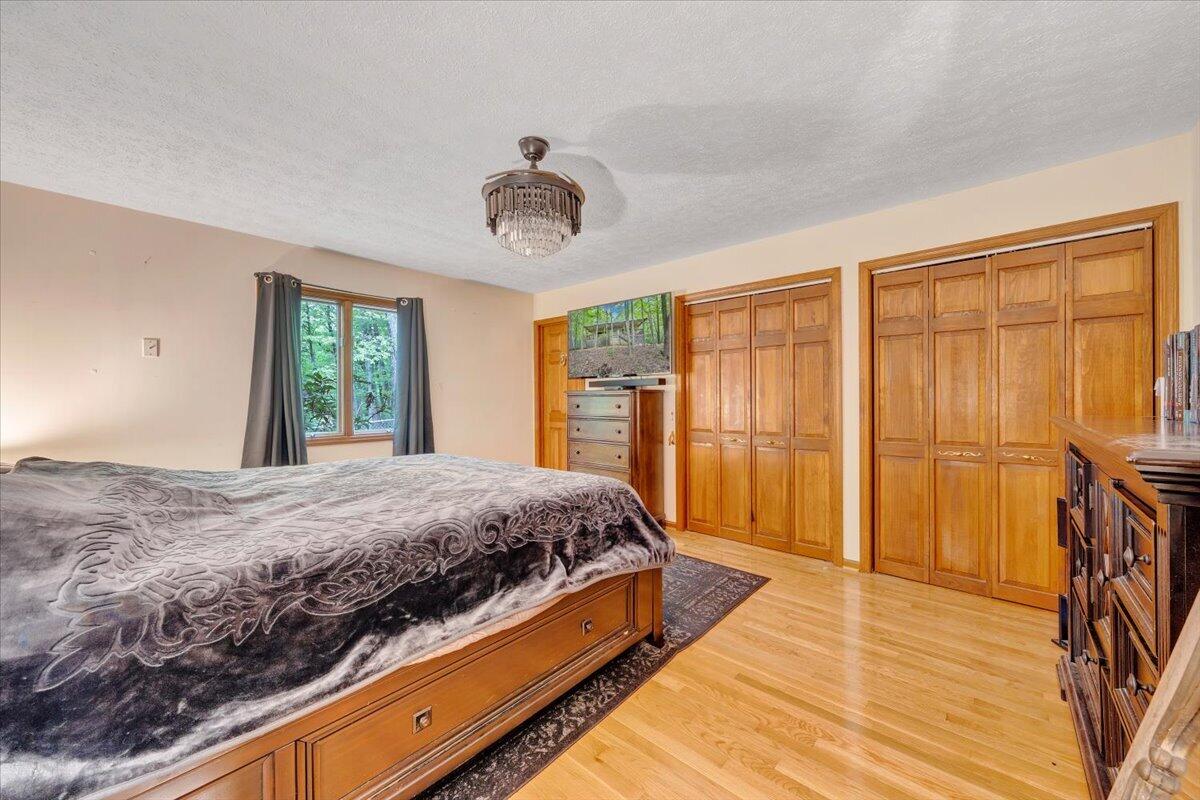 290 Silver Shadow Road Hardy, VA 24101 - Photo 17 of 62 a bedroom with a large bed and a chandelier
