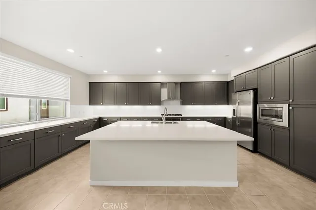 a large kitchen with stainless steel appliances kitchen island a large counter top and a fireplace