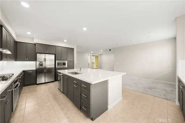 a kitchen with stainless steel appliances a sink and a refrigerator