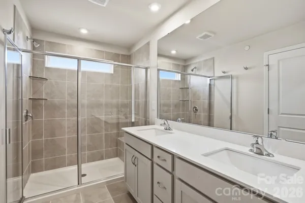 a bathroom with a shower sink and mirror