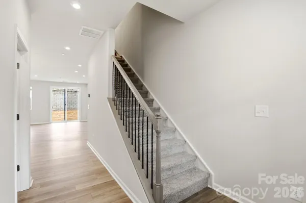 a view of a hallway with wooden floor and staircase
