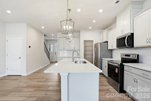 a large kitchen with stainless steel appliances kitchen island granite countertop a sink and cabinets