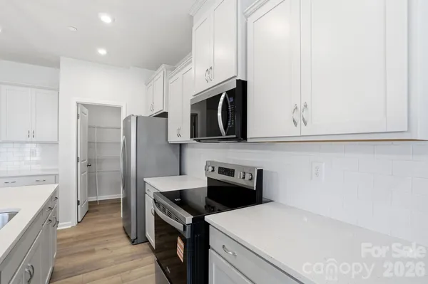 a kitchen with stainless steel appliances a stove microwave and refrigerator
