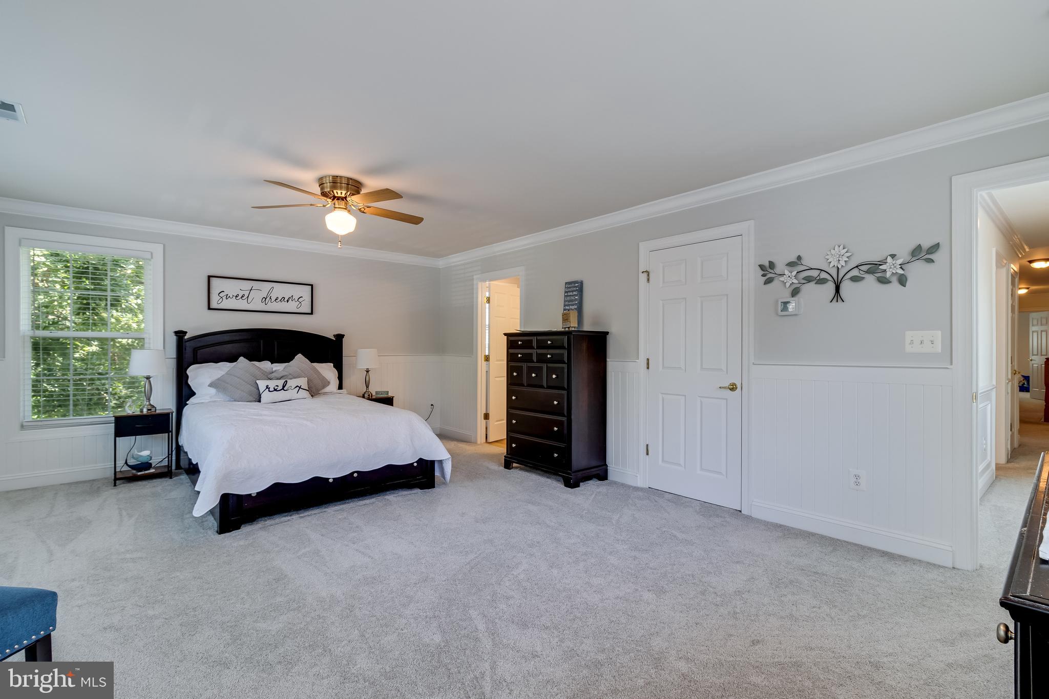11375 Ethan Court Swan Point, MD 20645 - Photo 37 of 55 a spacious bedroom with a bed and a chandelier