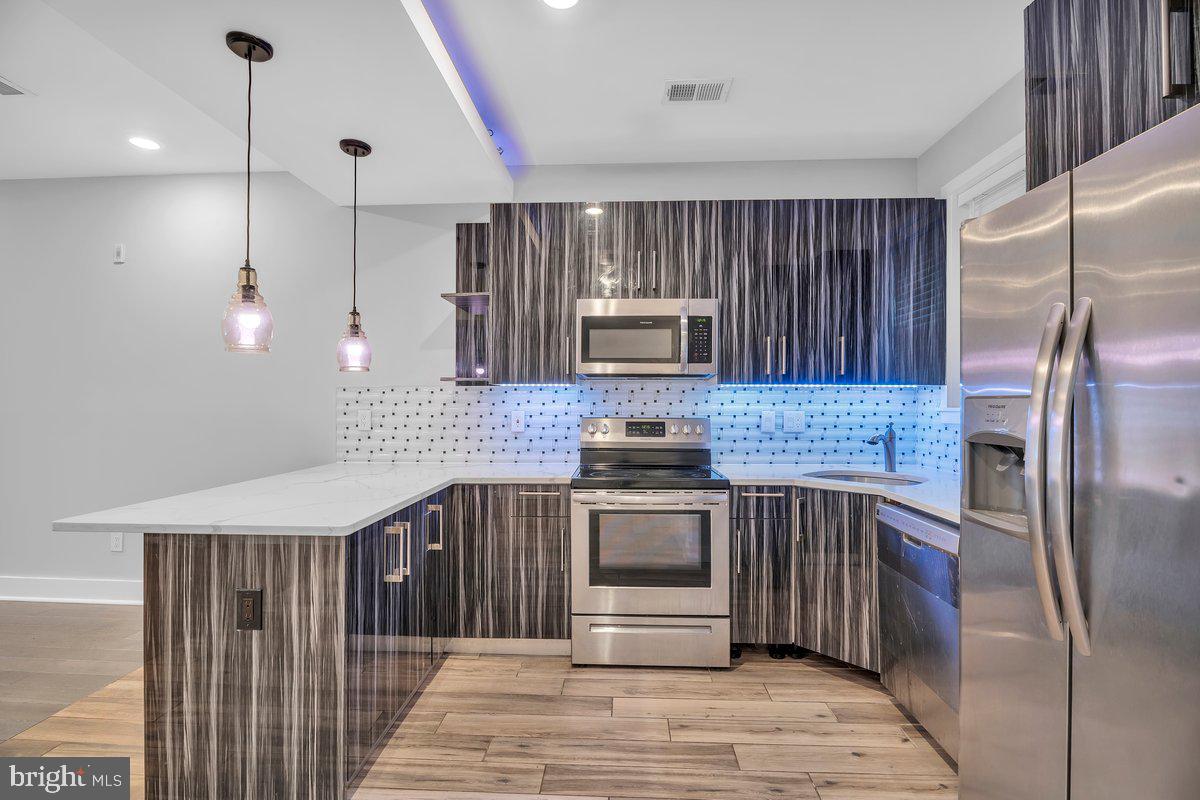 2562 Frankford Avenue, Unit 2 Philadelphia, PA 19125 - Photo 11 of 23 a kitchen with stainless steel appliances granite countertop a refrigerator a stove a sink and a microwave