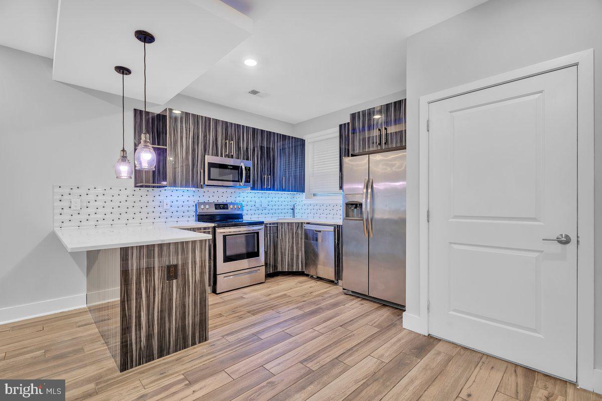 2562 Frankford Avenue, Unit 2 Philadelphia, PA 19125 - Photo 9 of 23 a kitchen with kitchen island granite countertop wooden floors stainless steel appliances and sink