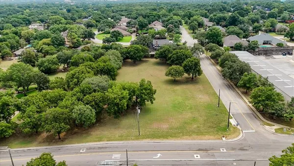 an aerial view of residential houses with outdoor space and trees