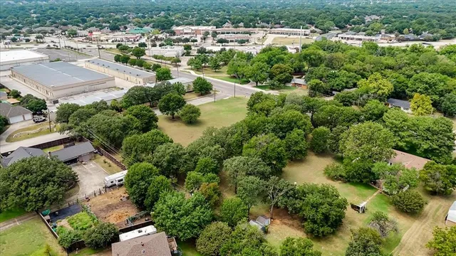 an aerial view of residential houses with outdoor space and trees all around