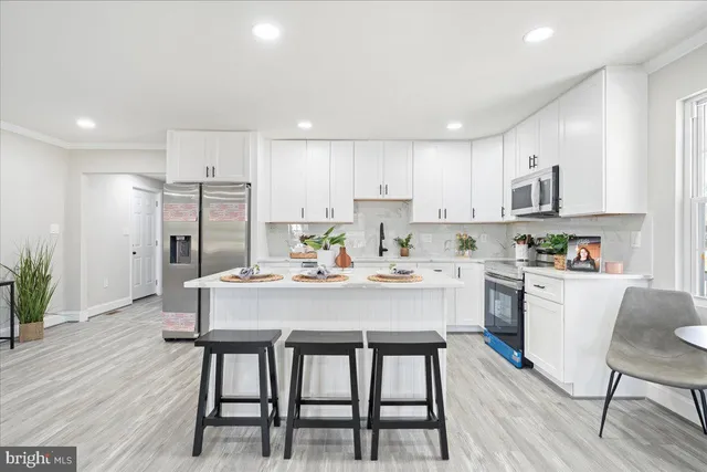 a kitchen with a dining table chairs refrigerator and cabinets