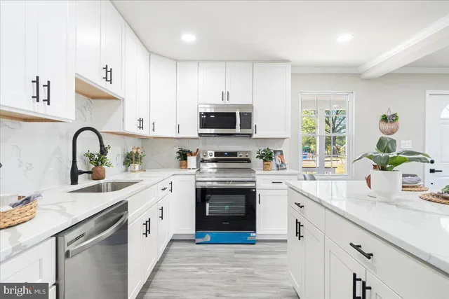 a kitchen with white cabinets stainless steel appliances and a sink