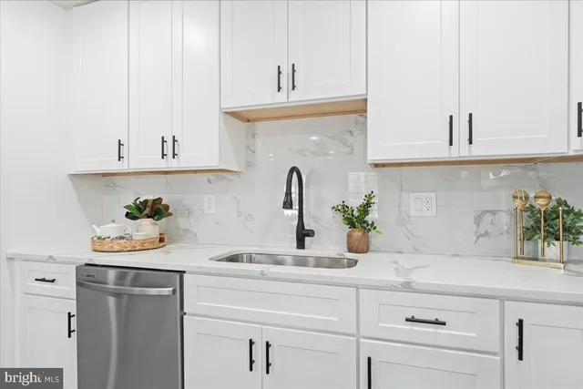 a kitchen with white cabinets and a sink