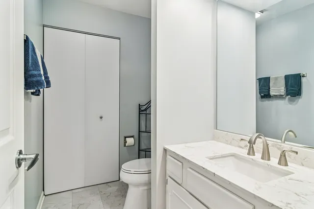 a bathroom with a sink vanity mirror and toilet