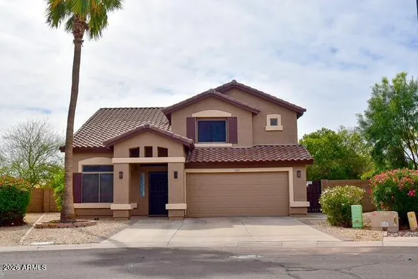 a front view of a house with a garden and yard
