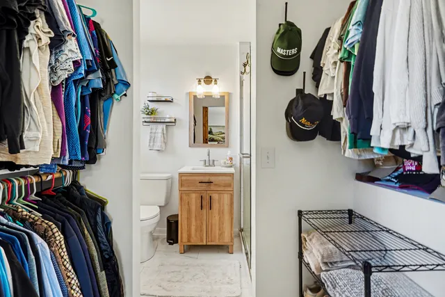 a view of walk in closet with clothes and shoes