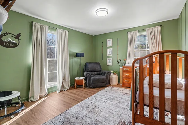 a bedroom with a bed and wooden floor