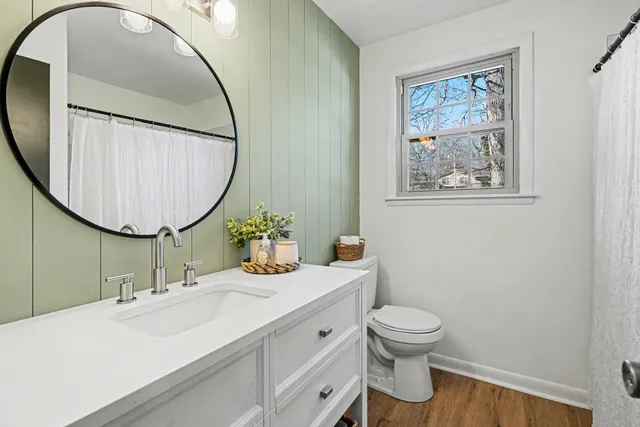 a bathroom with a toilet sink and mirror