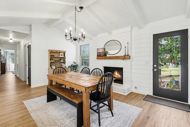a dining room with furniture a chandelier and wooden floor