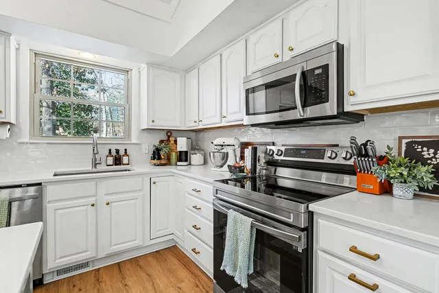a kitchen with stainless steel appliances granite countertop a stove a sink and a microwave