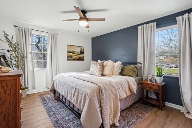 a bedroom with a bed wooden floor and window