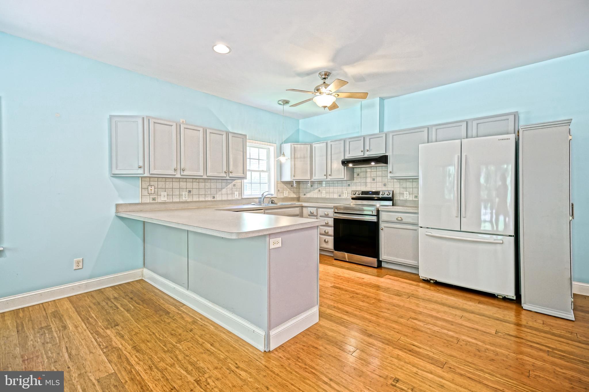 30869 Ridge Court Lewes, DE 19958 - Photo 12 of 42 a kitchen with stainless steel appliances granite countertop a stove a sink and a refrigerator