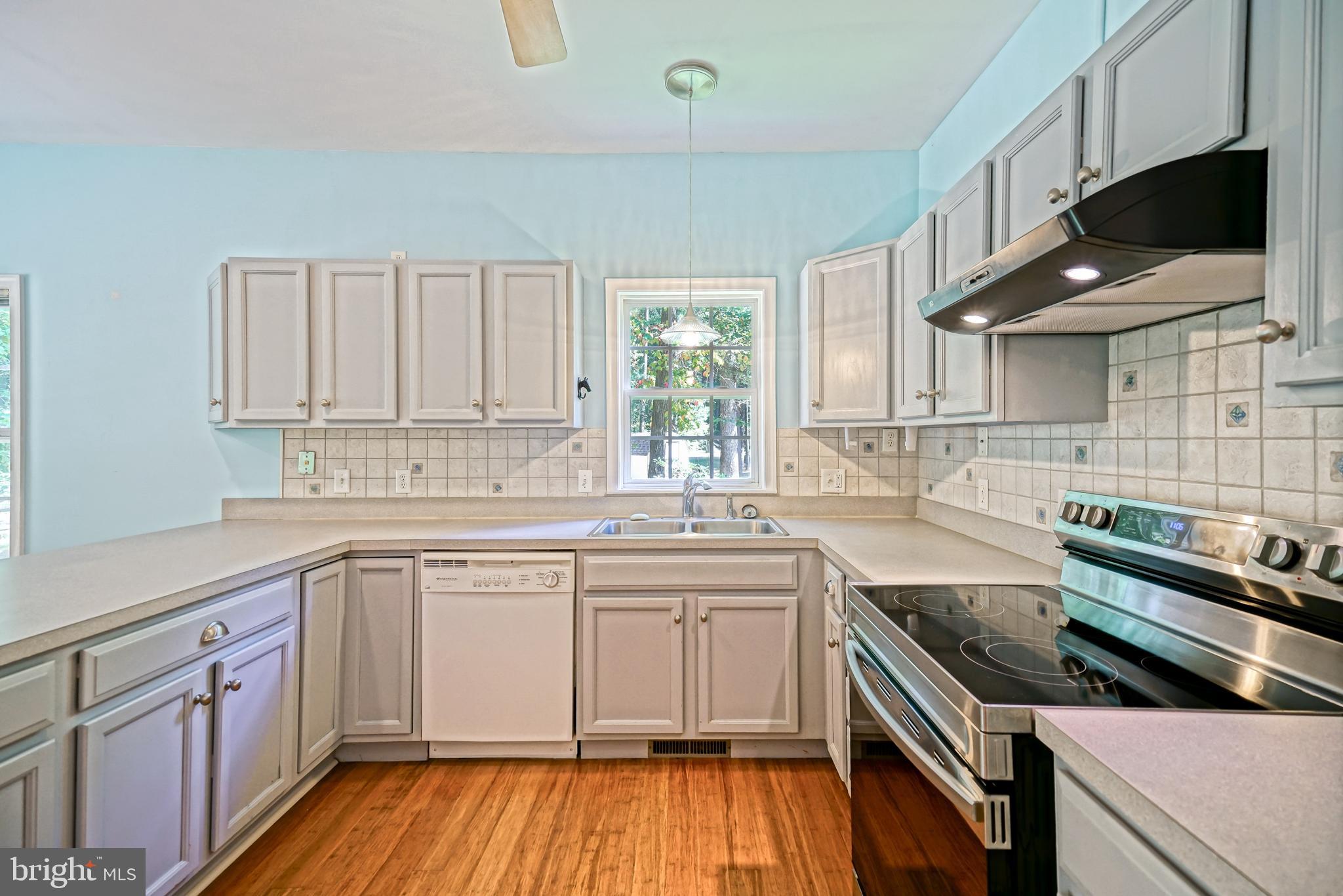 30869 Ridge Court Lewes, DE 19958 - Photo 13 of 42 a kitchen with a sink stove top oven and cabinets