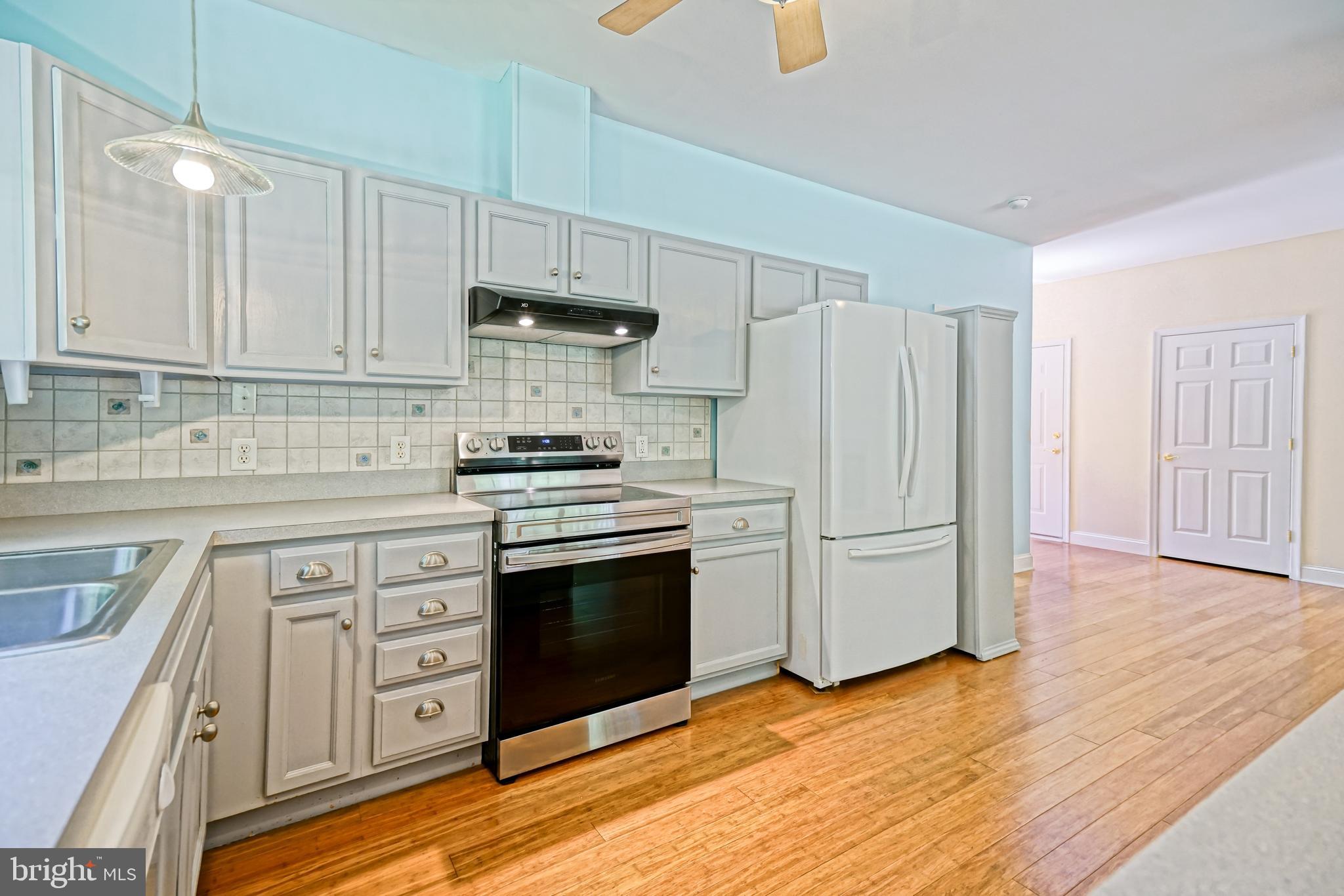 30869 Ridge Court Lewes, DE 19958 - Photo 18 of 42 a kitchen with stainless steel appliances white cabinets and a refrigerator