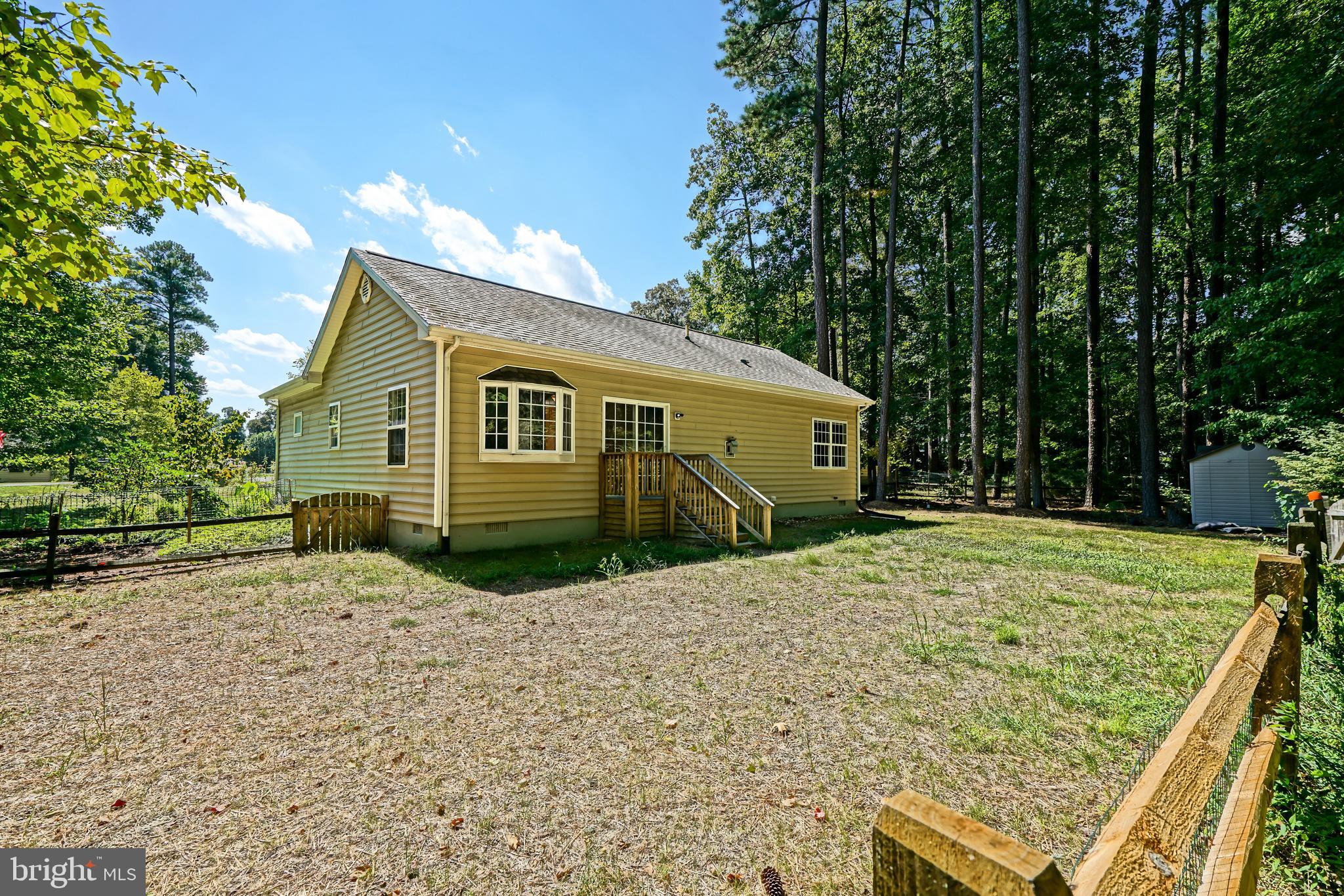 30869 Ridge Court Lewes, DE 19958 - Photo 39 of 42 a backyard of a house with large trees and barbeque oven