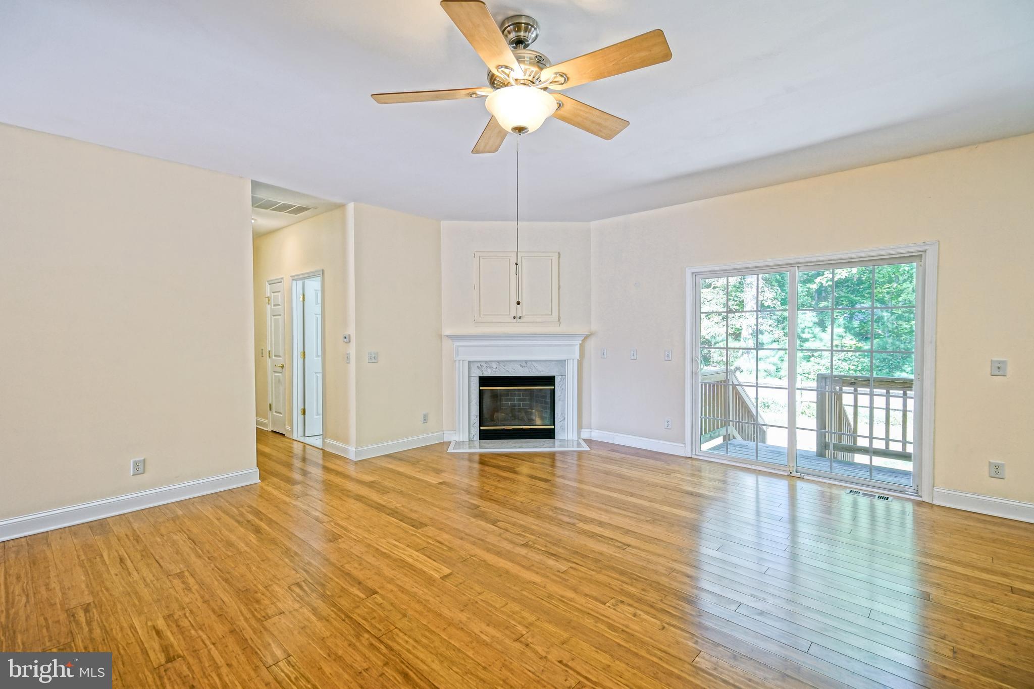 30869 Ridge Court Lewes, DE 19958 - Photo 6 of 42 a view of a livingroom with a fireplace a ceiling fan and wooden floor