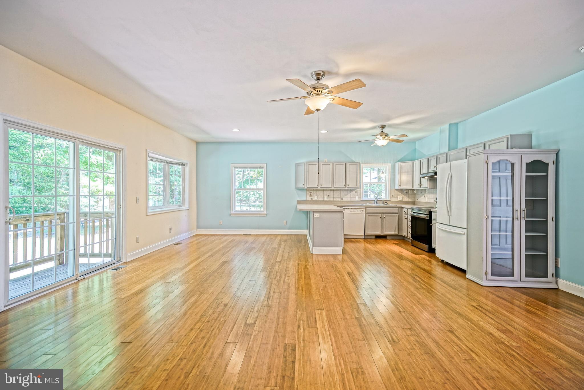 30869 Ridge Court Lewes, DE 19958 - Photo 8 of 42 a large room with chandelier fan and windows