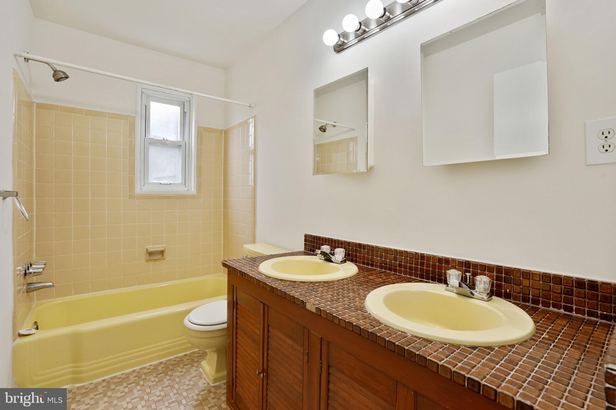 2911 Farm Road Alexandria, VA 22302 - Photo 18 of 35 a bathroom with a granite countertop sink a toilet a mirror and bathtub