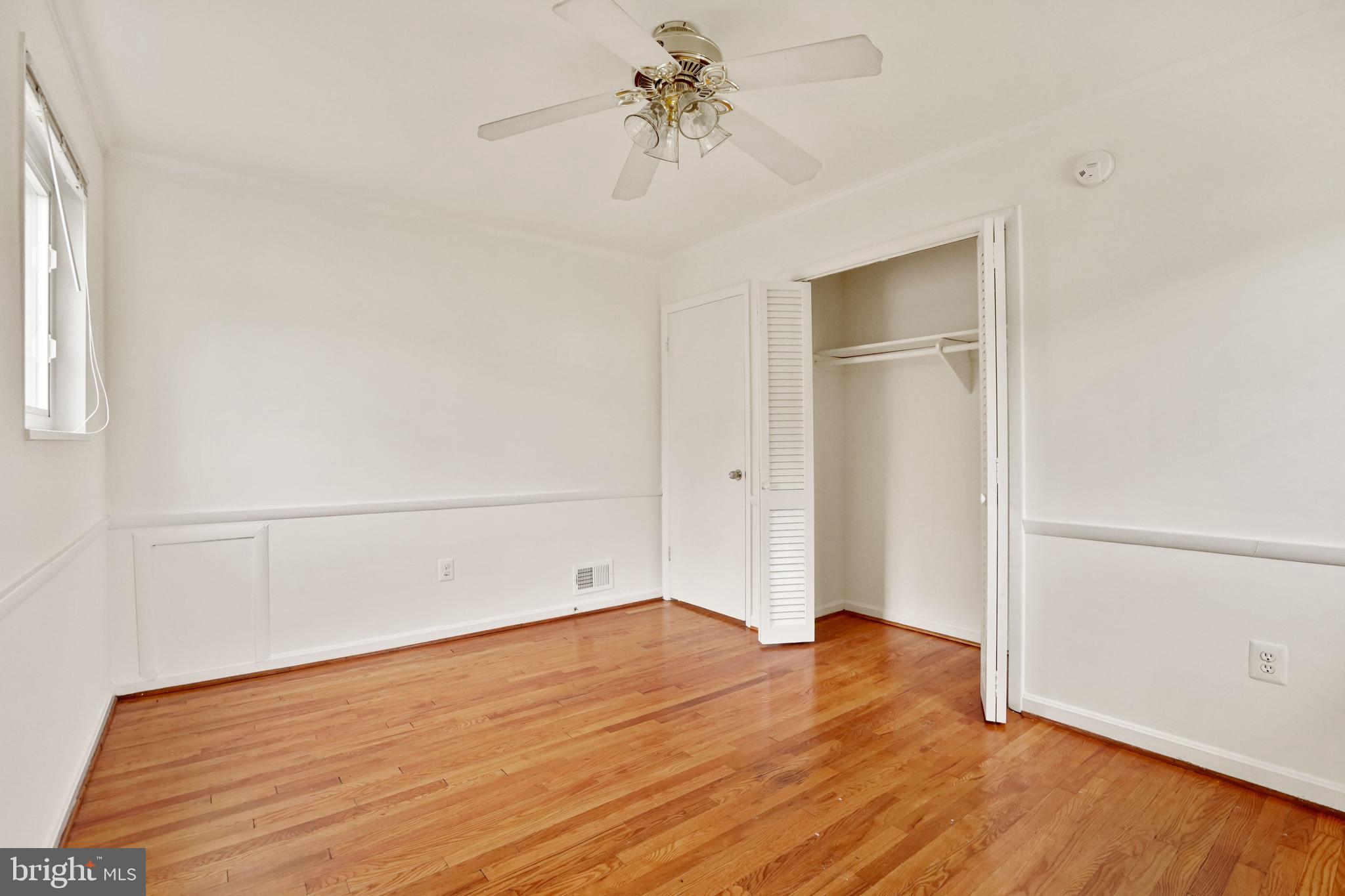 2911 Farm Road Alexandria, VA 22302 - Photo 22 of 35 an empty room with wooden floor chandelier fan and windows