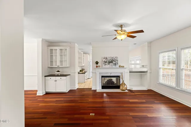 a living room with stainless steel appliances hardwood floor and a fireplace