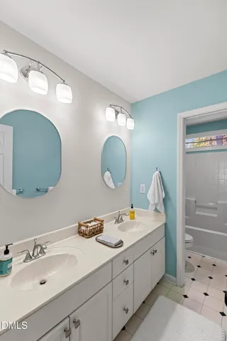 a bathroom with a double vanity sink and a mirror