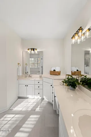 a spacious bathroom with double vanity and a mirror