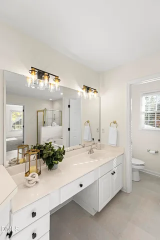 a bathroom with a double vanity sink toilet and mirror