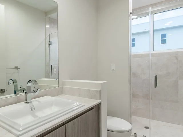a bathroom with a sink toilet vanity and shower