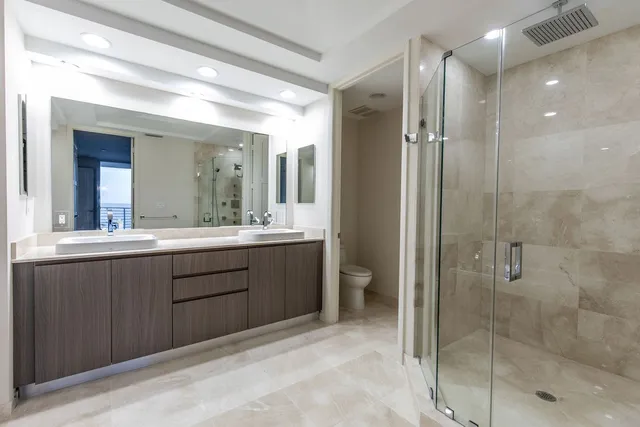 a bathroom with a double vanity sink mirror and shower