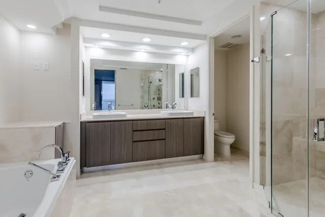 a bathroom with a double vanity sink a toilet and a mirror