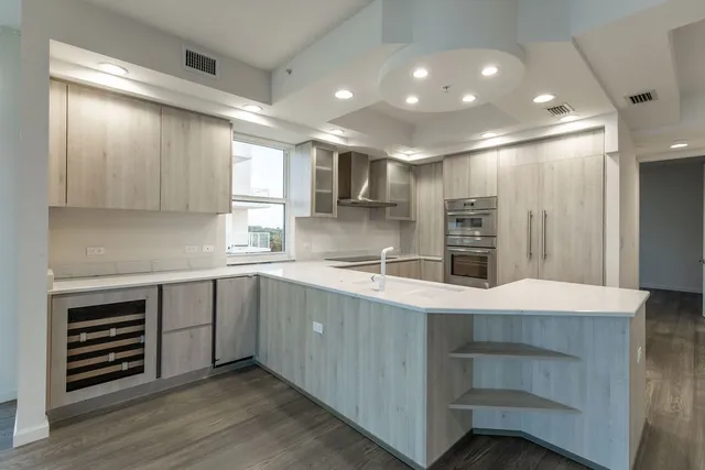 a kitchen with a sink cabinets stainless steel appliances and a window
