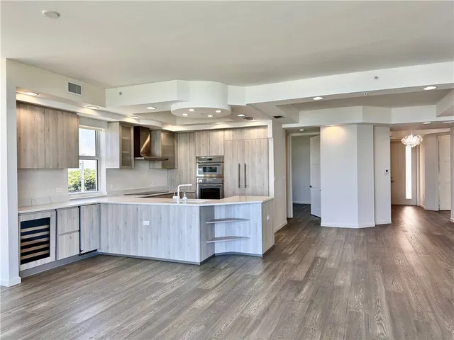 a kitchen with stainless steel appliances wooden floors and view living room