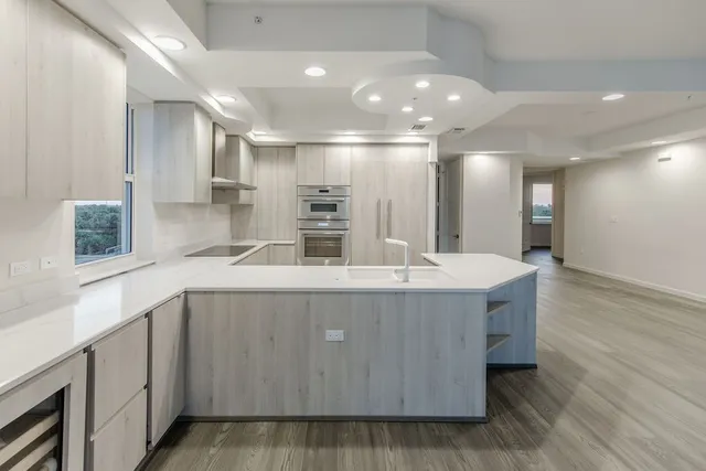 a view of kitchen with center island wooden floor and living room