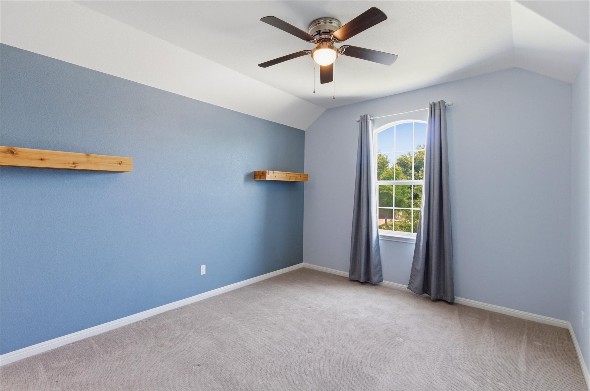 1511 Rimstone Drive Cedar Park, TX 78613 - Photo 26 of 39 A quiet bedroom featuring sloped ceilings and ample natural light from an arched window.
