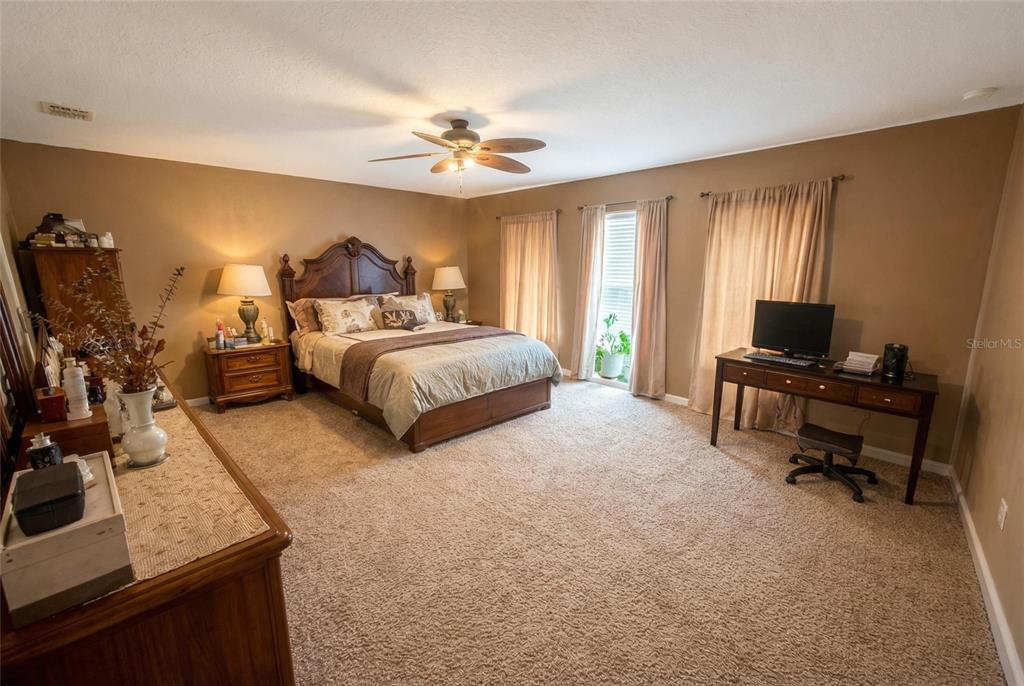 217 Tres Reyes Lane Groveland, FL 34736 - Photo 12 of 20 a bedroom with bed and a chandelier