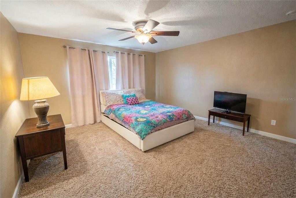 217 Tres Reyes Lane Groveland, FL 34736 - Photo 16 of 20 a bedroom with a bed and a table in it